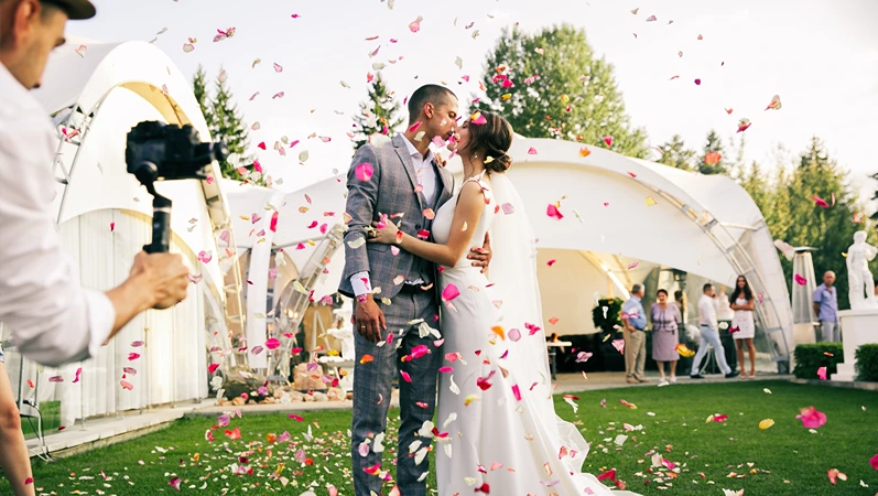 photographer shoots couple with rose petals in a wedding